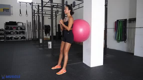 Squat avec ballon de stabilité contre un mur