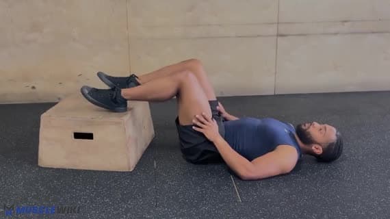 Most biodrowy — nogi na podwyższeniu (z ciężarem własnego ciała)