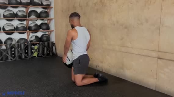 قطع الخشب بالكرة الطبية أثناء الركوع