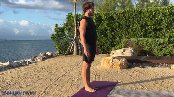 Flexion avant debout, jambes écartées, en tenant les talons