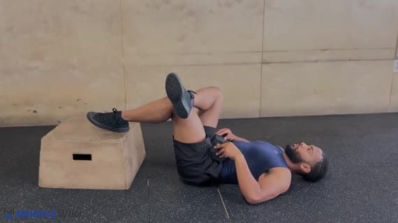 جسر الأرداف بوضعية الرقم 4 مع الدمبل والقدمين مرفوعتين